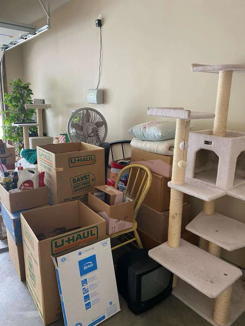 A garage stacked with moving boxes and household items before a cleanout
